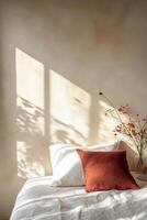 Soft sunlight casts shadows on a cozy bed with decorative pillows and floral accents in a serene room photo