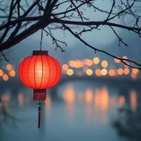 Red lantern illuminating riverside at dusk with city lights in background photo