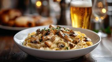 Delicious creamy mushroom pasta served with a refreshing cold beer in a cozy dining setting photo