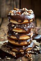 Chocolate glazed donuts stacked with nuts on a rustic wooden background photo