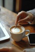 Coffee preparation and laptop work at a rustic table in a cozy setting photo