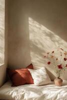 Soft sunlight casts shadows on a cozy bed with decorative pillows and floral accents in a serene room photo