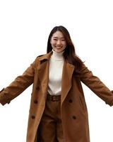 A woman with long brown hair smiles in a brown coat, white turtleneck, and brown boots, against on white background photo
