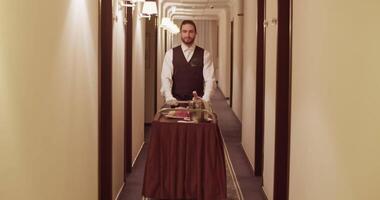 Elegant room service waiter rolling cart in hotel hall video