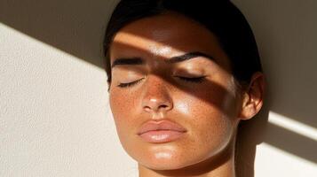 Close up of a womans face with freckles and closed eyes, sunlit skin photo