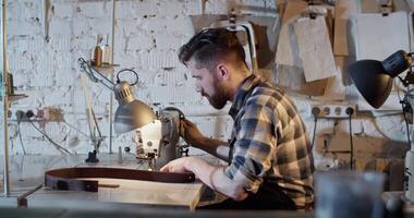 Craftsman using sewing machine in workshop video