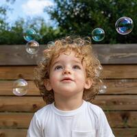 Toddler looking up at bubbles photo