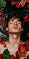Man submerged in water with autumn leaves photo
