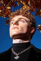 Young man with red hair looking up at the sky in autumn photo