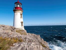 Lighthouse on a rocky cliff overlooking the ocean photo