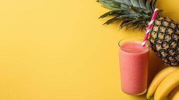 Pink smoothie with pineapple and banana on yellow background photo