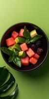 Delicious summer fruit salad in a black bowl photo