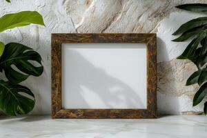 Blank square wooden frame mockup with tropical leaves on marble surface photo