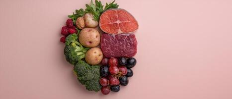 Heart shaped arrangement of healthy food on pink background photo