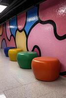Colorful leather poufs in a modern hallway with abstract wall art photo