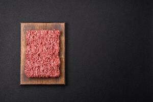 Fresh raw ground minced beef with salt and spices photo