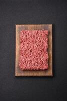 Fresh raw ground minced beef with salt and spices photo