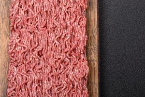 Fresh raw ground minced beef with salt and spices photo