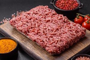 Fresh raw ground minced beef with salt and spices photo