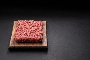 Fresh raw ground minced beef with salt and spices photo