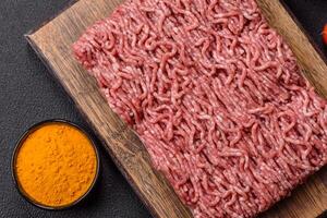 Fresh raw ground minced beef with salt and spices photo