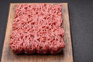 Fresh raw ground minced beef with salt and spices photo