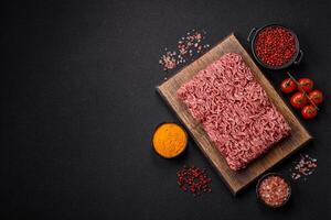 Fresh raw ground minced beef with salt and spices photo