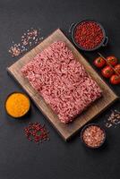 Fresh raw ground minced beef with salt and spices photo