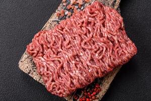 Fresh raw ground minced beef with salt and spices photo