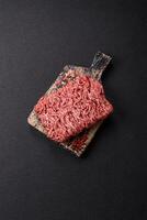 Fresh raw ground minced beef with salt and spices photo