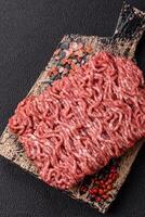 Fresh raw ground minced beef with salt and spices photo