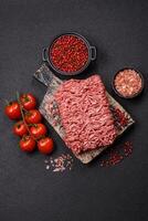 Fresh raw ground minced beef with salt and spices photo