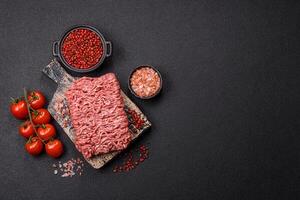 Fresh raw ground minced beef with salt and spices photo