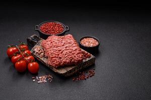Fresh raw ground minced beef with salt and spices photo