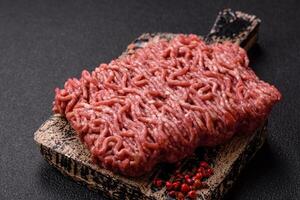 Fresh raw ground minced beef with salt and spices photo