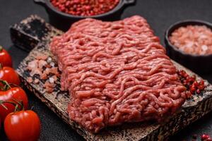 Fresh raw ground minced beef with salt and spices photo