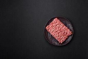 Fresh raw ground minced beef with salt and spices photo