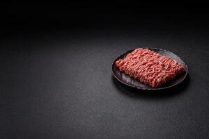 Fresh raw ground minced beef with salt and spices photo