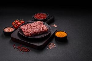 Fresh raw ground minced beef with salt and spices photo