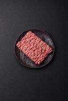 Fresh raw ground minced beef with salt and spices photo