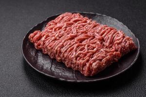 Fresh raw ground minced beef with salt and spices photo