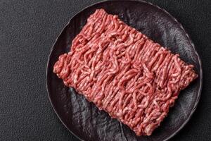 Fresh raw ground minced beef with salt and spices photo