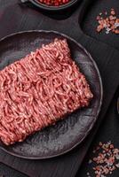 Fresh raw ground minced beef with salt and spices photo
