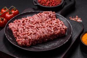 Fresh raw ground minced beef with salt and spices photo