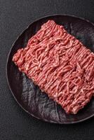 Fresh raw ground minced beef with salt and spices photo