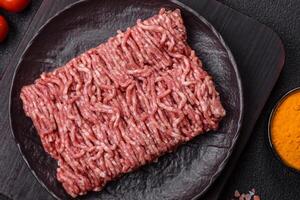 Fresh raw ground minced beef with salt and spices photo