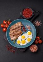 A hearty, delicious breakfast with fried eggs, bacon and tomatoes photo