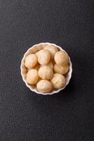Delicious nutritious macadamia nuts in ceramic bowl photo
