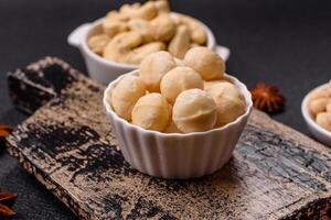 Delicious nutritious macadamia nuts in ceramic bowl photo