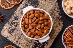 Delicious nutritious cedar nuts in ceramic bowl photo
